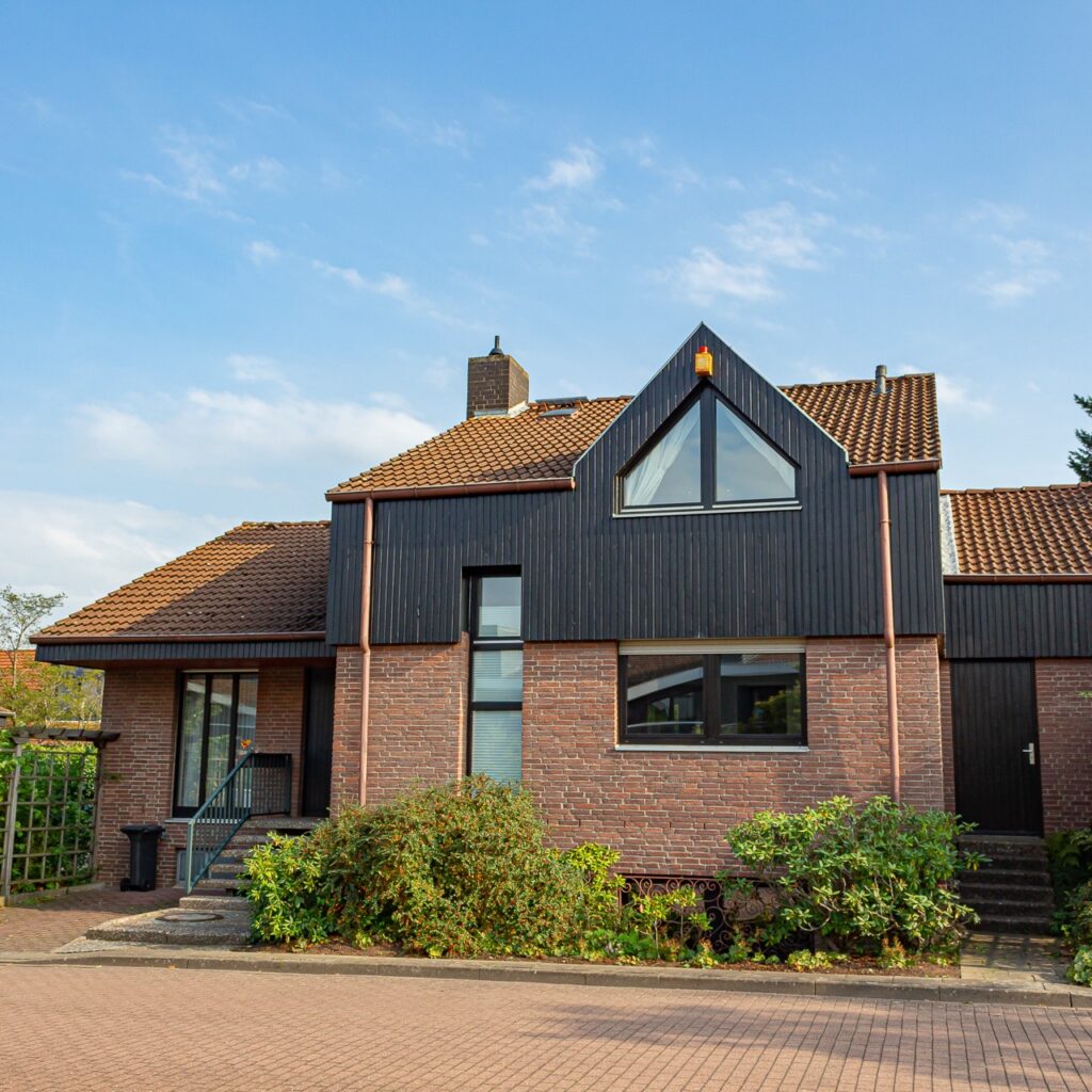 Architektenhaus in Hemmingen-Westerfeld mit dunkler Holzverkleidung über Klinkersockel
